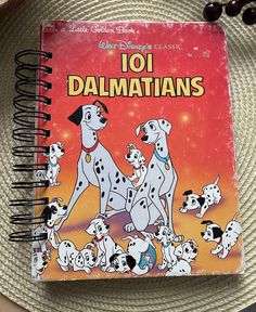 a book with the title 101 dalmatians written on it sitting on a plate