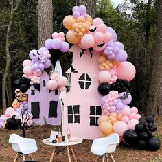 an outdoor party setup with balloons and decorations in the shape of a pink house, surrounded by black and white chairs