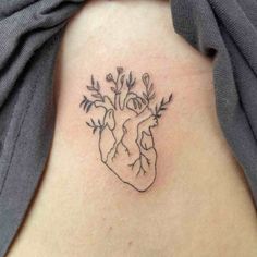 a small heart tattoo on the back of a woman's rib - up stomach