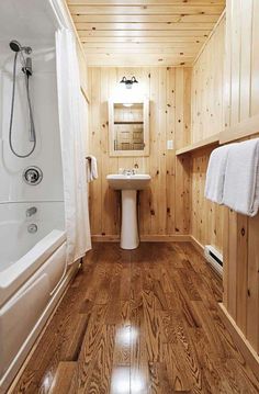 a bathroom with wood paneling and white fixtures