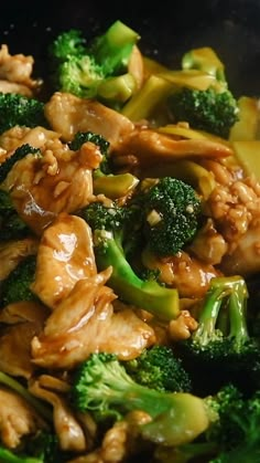 chicken and broccoli stir frying in a wok with sauce on top