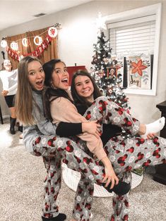 three girls in matching pajamas are posing for the camera while one girl is on her back