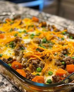 a casserole dish with meat, cheese and vegetables in it on a counter