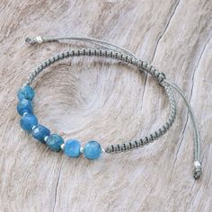 a blue beaded bracelet on a wooden surface