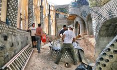 three men are working on an art project in the middle of a construction area with wooden planks