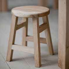 a wooden stool sitting on top of a hard wood floor