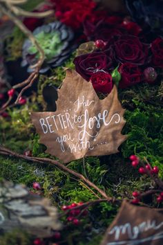 a leaf that has been placed on some moss with flowers around it and the words, better to love you more