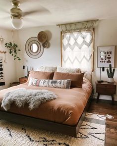 a large bed sitting in a bedroom on top of a wooden floor next to a window