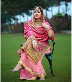 a woman sitting on top of a chair wearing a pink dress and headpieces