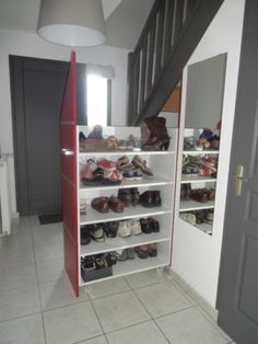 the closet is full of shoes and purses in it's storage area next to the stairs