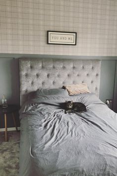 a cat laying on top of a bed in a bedroom