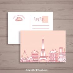 two envelopes with the eiffel tower in pink and white, on wooden background