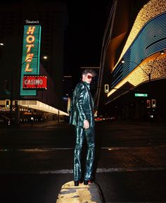 a man standing on the side of a road at night