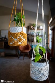 two hanging planters with plants in them, one is white and the other is yellow