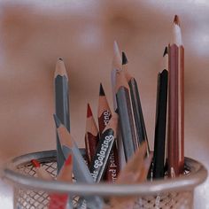 there are many pencils in the cup and one is red, black, gray, and white