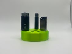 two electronic gadgets are sitting on a green holder with the same device in it