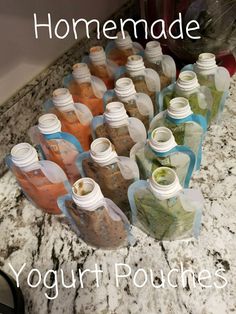 many bottles are lined up on the counter in order to be filled with different colored liquids