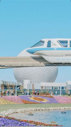 a monorail train passing over the top of a flower garden