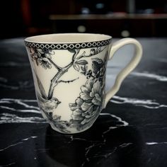 a white and black coffee cup sitting on top of a table