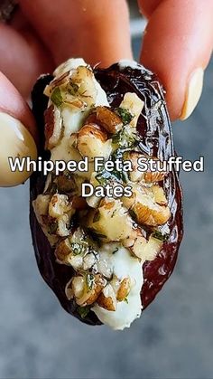 someone is holding an item in their hand with the words whipped feta stuffed dates