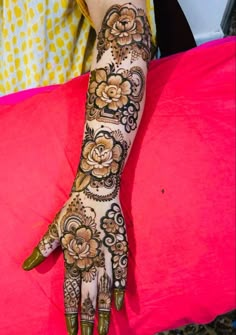 a woman's hand with henna tattoos on her left arm and the bottom half of