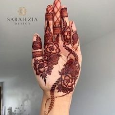 a woman's hand with henna tattoos on it