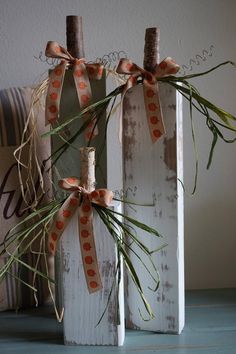 two wooden vases decorated with orange and white ribbons