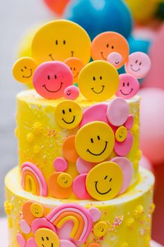 a three tiered cake with smiley faces on it