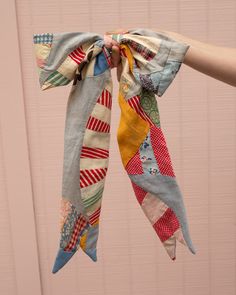 a person holding up a multicolored scarf