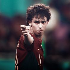 a young man holding a tennis racquet on top of a tennis ball court