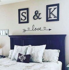 a bed with two framed pictures on the wall above it and love signs above it