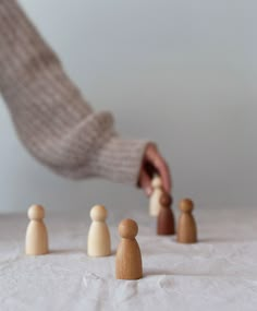 a person placing wooden pegs on top of each other