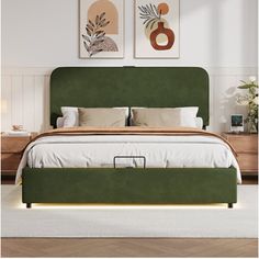 a bed with green headboard and foot board in a white room next to two paintings on the wall