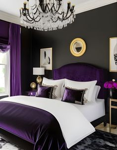 a purple and white bedroom with chandelier