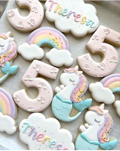 decorated cookies with unicorns, clouds and rainbows are on a tray that says happy 5th birthday