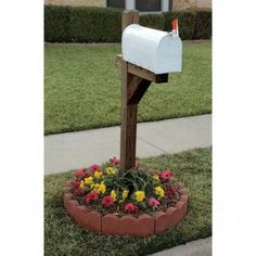 a mailbox sitting in the middle of a flower bed