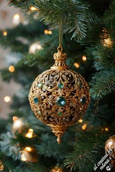 an ornament hanging from the christmas tree in front of a gold and green garland