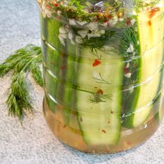 a jar filled with cucumbers and herbs