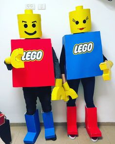 two people in lego costumes holding up signs