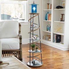 a living room filled with furniture and a tall tower next to a white chair on top of a hard wood floor