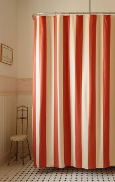 an orange and white shower curtain in a bathroom