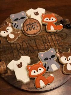 decorated cookies on a wooden platter with names and pictures in the shape of animals