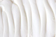 a close up view of white frosting on a cake