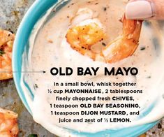 a person holding up a plate with shrimp and cream sauce on it that reads old bay mayo