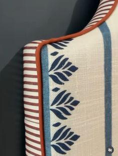 a close up of a blue and white blanket on a chair with an orange trim