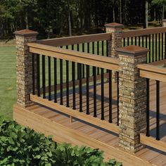 a wooden deck with black iron railings and stone pillars