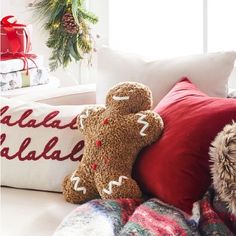 two teddy bears sitting on top of pillows in front of a christmas tree and presents