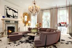 a living room filled with lots of furniture and a chandelier hanging from the ceiling