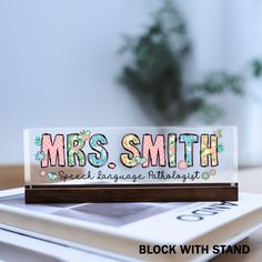 there is a sign that says mrs smith on top of a table next to some books