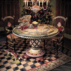 a christmas tree is in the middle of a dining room table with chairs around it